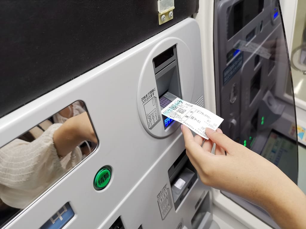 將中獎的馬券放入售票機兌獎